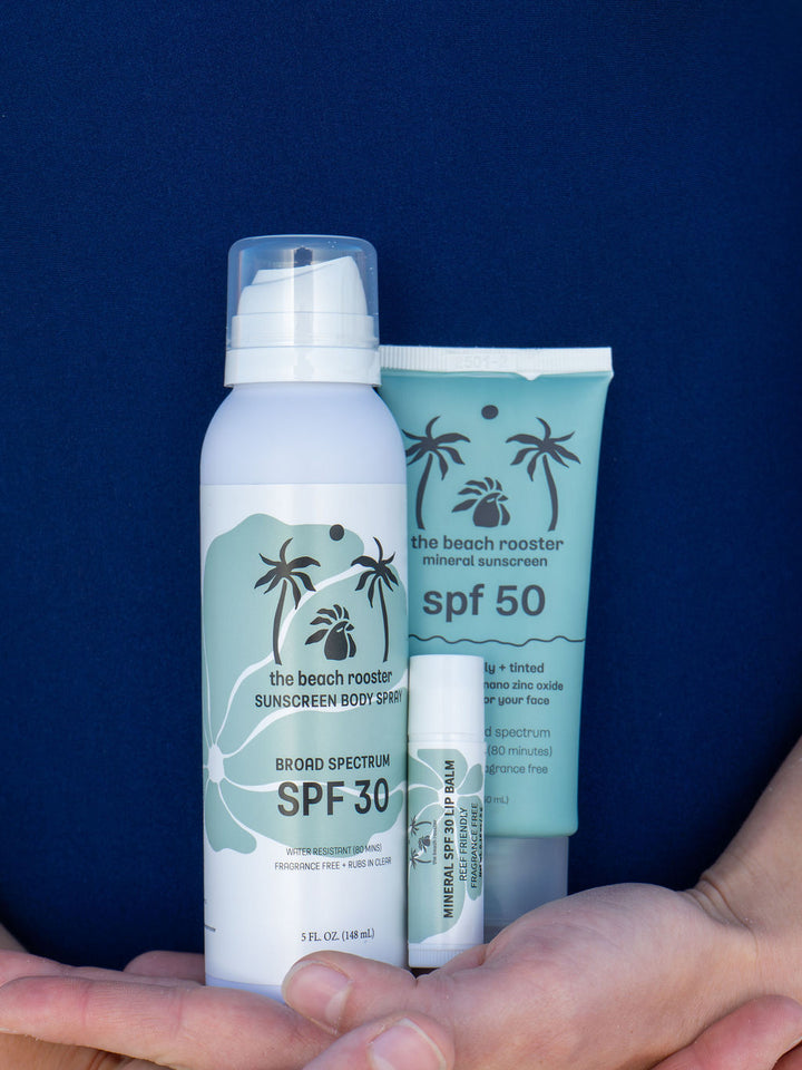 The Beach Rooster Bundle SPF Mineral Sunscreen, Face, Body and Lips with a woman holding it in both hands close to her body 